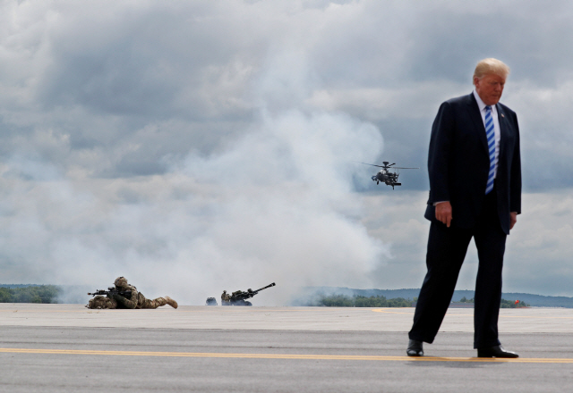 도널드 트럼프 미국 대통령이 13일(현지시간) 뉴욕 포트 드럼을 방문해 미 육군 제10산악사단의 헬리콥터와 포 공격 시연을 보고 있다./로이터연합뉴스