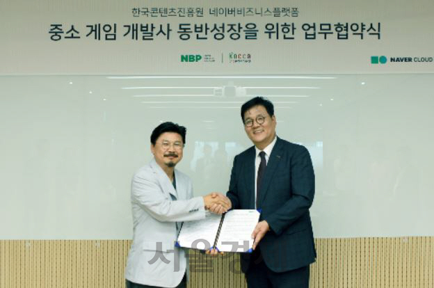 박원기(왼쪽)네이버비즈니스플랫폼(NBP)대표와 김영준 한국콘텐츠진흥원 원장이 한국콘텐츠진흥원 네이버비즈니스플랫폼 중소 게임 개발사 동반 성장을 위한 업무협약식에서 업무협약서를 들고 악수를 나누고 있다./사진제공=네이버