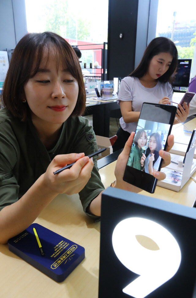 서울 광화문 KT 올레스퀘어를 찾은 시민들이 삼성전자의 하반기 전략 스마트폰 ‘갤럭시노트9’을 체험하고 있다. /연합뉴스