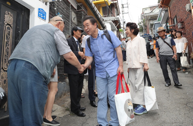 ‘옥탑방 한달살이’를 마친 박원순 서울시장이 19일 오전 부인 강난희씨와 함께  서울 강북구 삼양동 현장을 떠나며 주민들과 인사를 나누고 있다./연합뉴스