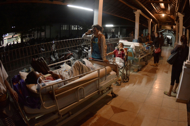 19일(현지시간) 인도네시아 발리의 한 병원에서 치료를 받던 환자들이 인근 롬복에서 발생한 강진으로 인해 바깥으로 피신하고 있다. /발리=로이터연합뉴스