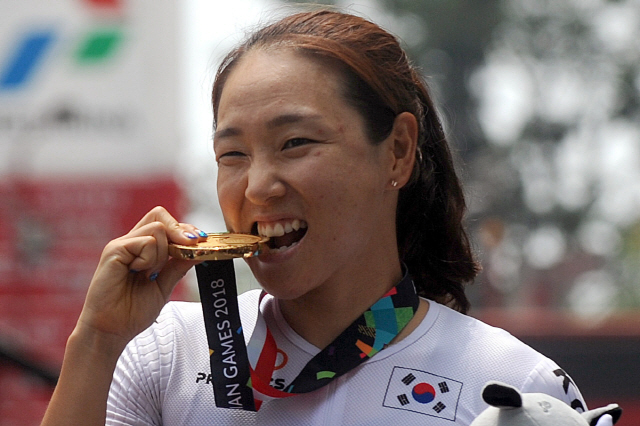 한국 도로 사이클 간판 나아름이 24일 여자 도로독주 우승으로 아시안게임 2관왕을 달성한 뒤 시상식에서 금메달을 깨물어 보이고 있다. /수방=신화연합뉴스