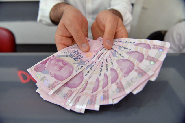 도널드 트럼프 미국 대통령이 터키 제품에 대해 ‘2배 관세’를 부과하겠다고 하자 터키 리라화가 폭락한 가운데 터키 앙카라에서 한 환전상이 리라화 지폐를 펼치고 있다. /연합뉴스