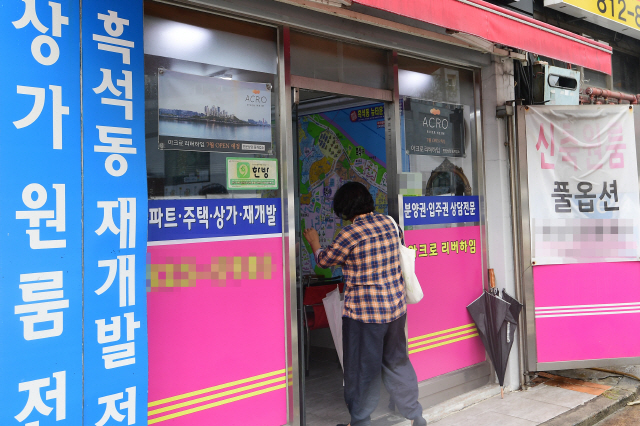 국토교통부가 서울 동작·종로·동대문·중구 등 4개 자치구를 투기지역으로 추가 지정한 27일 동작구 흑석동의 한 부동산 중개업소에 방문객이 들어서고 있다.  /권욱기자