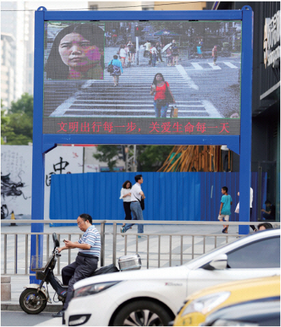작년 8월 중국 난징 지역 교차로에서 무단횡단하는 여성의 얼굴이 안면인식 시스템 기능을 갖춘 스크린에 비쳐지고 있다.                                 출처: 포춘US