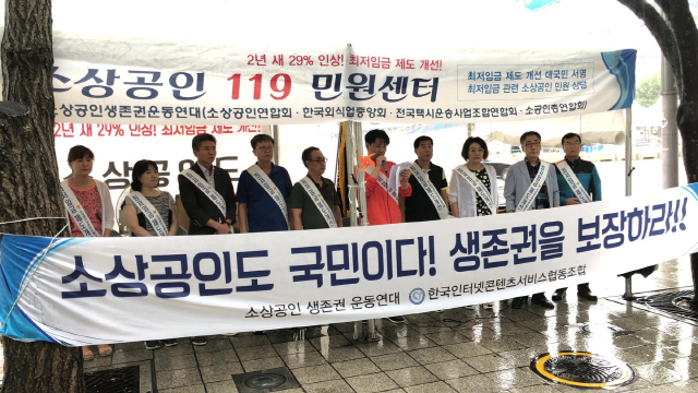 최윤식(오른쪽 다섯번째) 한국인터넷콘텐츠서비스협동조합 회장이 28일 서울 광화문에 설치된 ‘소상공인 119 민원센터’에서 최저임금 차등적용과 최저임금 내 주휴수당 산입을 촉구하는 발언을 하고 있다./사진제공=소상공인연합회