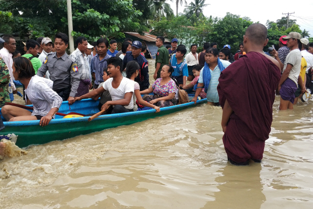 29일(현지시간) 미얀마 중부 바고의 스와르 차웅 댐에서 폭우로 범람한 물이 홍수조절용 배수로를 무너뜨리면서 하류지역에 홍수가 나자 주민들이 긴급 대피하고 있다. 이번 홍수로 최소 2명이 실종되고 5만명 이상의 이재민이 발생했다고 현지 언론과 외신이 보도했다. /네피도=로이터연합뉴스