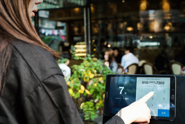 신세계백화점 강남점 내 식당 매장에서 한 고객이 태블릿PC를 이용해 대기 접수를 하고 있다. /사진제공=신세계