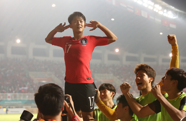 이승우가 지난 1일 2018 자카르타 팔렘방 아시안게임 남자 축구 결승 한일전에서 연장 전반 선제골을 터뜨린 뒤 광고판 위에 올라가 세리머니를 하고 있다.  /연합뉴스