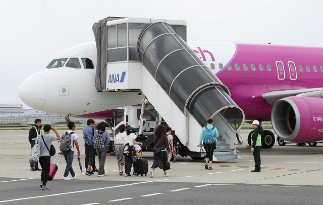 태풍 21호 제비의 영향으로 지난 4일부터 폐쇄됐던 일본 간사이 공항의 운영이 재개돼 7일 승객들이 비행기에 오르고 있다.   /이즈미사노=AFP연합뉴스