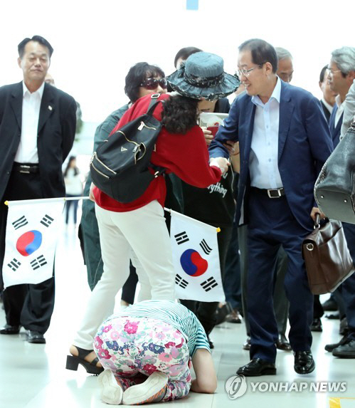 홍준표 자유한국당 전 대표가 지난 7월 11일 미국에서 휴식을 위해 인천공항으로 들어서자 한 지지자가 큰절을 하고 있다./연합뉴스