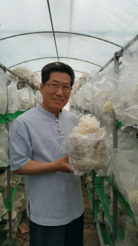 이용복 대표가 직접 원목으로 키운 꽃송이 버섯을 들어보이고 있다.