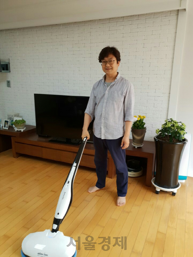김정택 오토싱 대표가 자택에서 자사의 물걸레 청소기를 이용해 청소를 하고 있다. /사진제공=오토싱