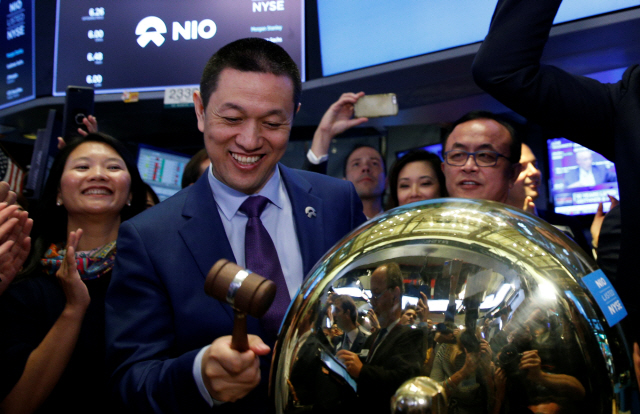 12일(현지시간) 중국판 ‘테슬라’로 불리는 전기차 스타트업 니오(NIO)의 최고경영자(CEO) 리빈이 미국 뉴욕증권거래소에서 상장을 알리는 종을 치고 있다. 니오는 이번 기업공개(IPO)를 통해 올해 미국에 상장한 중국 기업으로는 세 번째로 많은 10억달러(1조1,240억원)의 자금을 조달하게 됐다.   /뉴욕=로이터연합뉴스