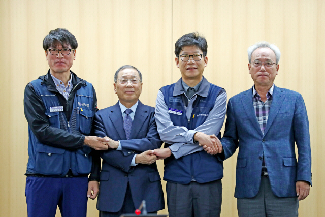 14일 오전 서울 광화문 경제사회노동위 대회의실에서 열린 쌍용차 노사 해고자 복직 잠정 합의에서 김득중 쌍용차지부장(왼쪽부터), 최종식 쌍용자동차 사장, 홍봉석 쌍용자동차 노조위원장, 문성현 경제사회노동위원장이 손을 맞잡고 기념촬영을 하고 있다. /연합뉴스