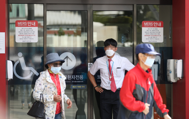 11일 오전 중동호흡기증후군(메르스) 환자가 격리 치료 중인 서울 종로구 서울대병원 응급의료센터 앞으로 마스크를 쓴 시민이 지나고 있다. /연합뉴스