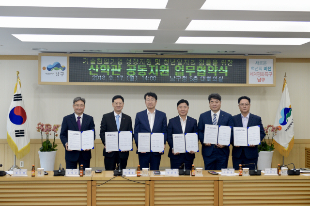 강낙규(왼쪽 두번째)기술보증기금 전무이사가 17일 부산시 남구청에서 열린 ‘기술창업기업 성장지원 및 청년일자리 창출을 위한 산·학·관 공동지원 업무협약’ 행사에서 박재범(〃세번째) 남구청장 등 관계자들과 함께 서명한 협약 문서를 들어 보이고 있다. /사진제공=기술보증기금