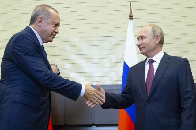 블라디미르 푸틴 러시아 대통령(오른쪽)과 레제프 타이이프 에르도안 터키 대통령이 17일(현지시간) 러시아 남부 도시 소치에서 만나 악수를 나누고 있다./소치=AP연합뉴스