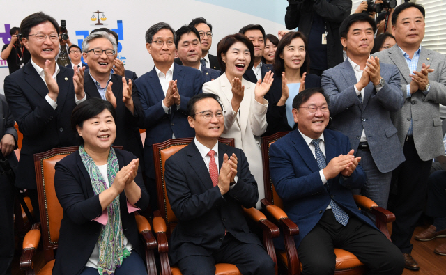 홍영표(앞줄 가운데) 원내대표를 비롯한 더불어민주당 지도부가 18일 오전 국회에서 문재인 대통령의 평양 순안공항 도착 장면 중계를 보며 박수치고 있다.          /연합뉴스