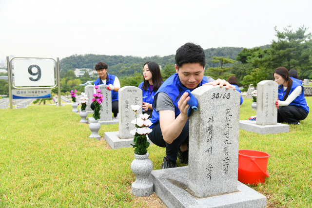 효성 직원들이 지난 19일 서울 동작구 국립서울현충원에서 묘역 정화 활동을 벌이고 있다. /사진제공=효성