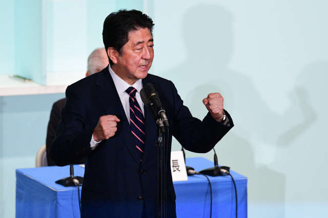 아베 신조 일본 총리가 20일 집권 자민당 총재 선거에서 3연임을 확정 지은 후 주먹을 들어 보이며 당선 소감을 밝히고 있다. /도쿄=AFP연합뉴스