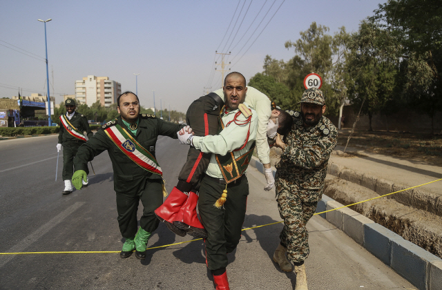 이란 군인들이 22일(현지시간) 군사퍼레이드 중 벌어진 총격사건으로 다친 부상자를 병원으로 옮기고 있다. /아흐바즈=신화연합뉴스