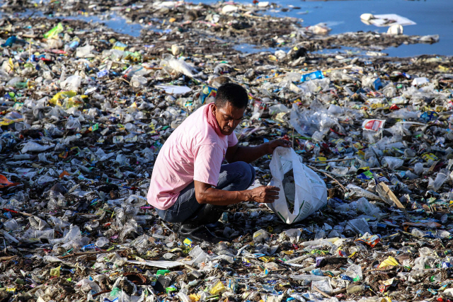 한 자원봉사자가 22일(현지시간) 필리핀 마닐라에서 쓰레기를 줍고 있다. /마닐라=AFP연합뉴스