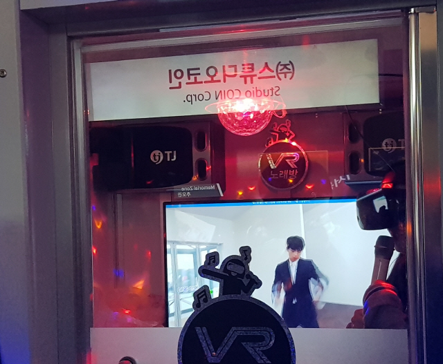 지난 4월 20일 서울 코엑스에서 열린 ‘서울 VRAR 엑스포 2018’에서 참석자들이 루씨드드림 부스 옆에 놓인 ‘VR 노래방’을 즐기고 있다./심우일기자