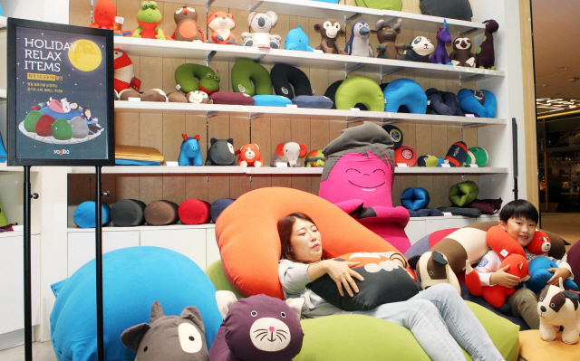 빈백(Bean Bag) 소파로 유명한 ‘요기보’의 잠실 롯데월드몰 팝업 스토어를 찾은 고객들이 26일 소파에 누워 체험하고 있다. 빈백 소파는 내부가 작은 알갱이로 채워져 있어 편안함과 안락함을 느낄 수 있으며 가장 대표적인 제품인 ‘요기보 맥스’는 크기가 170㎝에 달해 성인도 무리 없이 침대로 사용할 수 있다. /연합뉴스