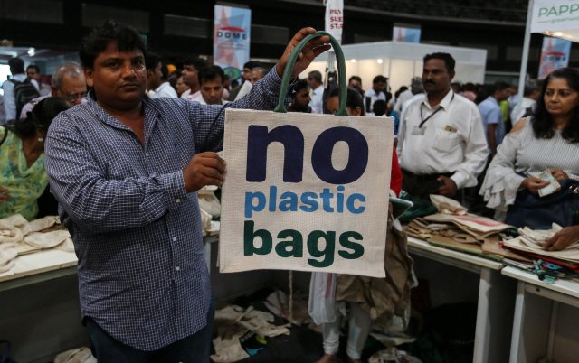 지난 6월 인도 뭄바이에서 한 남성이 ‘플라스틱 백 사용 금지’라고 적힌 삼베 소재 쇼핑백을 들고 있다. /뭄바이=EPA연합뉴스