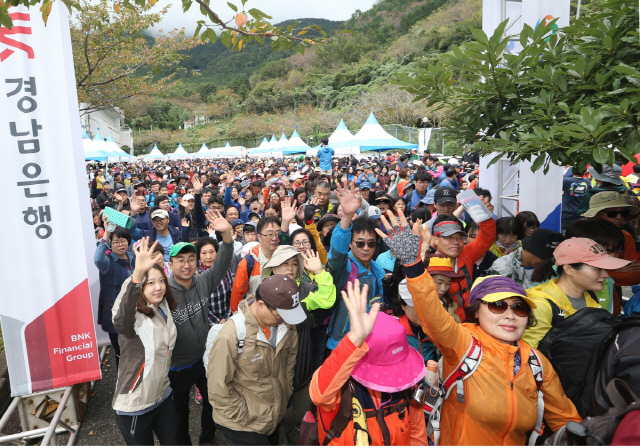 30일 BNK경남은행이 개최한 ‘2018 창원 둘레길 걷기대회’에서 참석자들이 손을 흔들며 걷고 있다. 진해 장복산 편백치유의숲 일대에서 열린 이번 행사에는 황윤철 은행장과 허성무 창원시장을 비롯해 4,000여명의 시민들이 참가했다. /사진제공=BNK경남은행