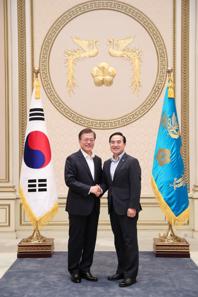 문재인 대통령 초청으로 청와대 오찬에 참석한 박홍근 의원이 문 대통령과 악수하며 기념사진을 찍고 있다.