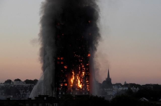지난해 6월 14일 영국 런던의 24층짜리 그렌펠 아파트가 화염에 휩싸여 있다. 이 화재로 72명이 목숨을 잃었다. /로이터연합뉴스