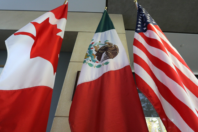 지난해 9월 북미자유무역협정(NAFTA·나프타) 재협상이 벌어지고 있는 캐나다 오타와의 한 건물 로비에 협상 당사국인 미국과 캐나다, 멕시코의 국기가 걸려있다. /AFP=연합뉴스