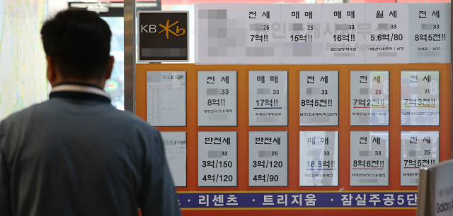 지난 2일 서울 송파구의 한 부동산 중개사무소 앞에서 한 고객이 매매 및 전세 시세판을 들여다보고 있다./연합뉴스