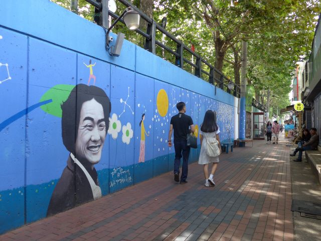 ‘김광석 다시 그리기 길’을 찾은 방문객들이 벽화를 구경하며 산책을 즐기고 있다.