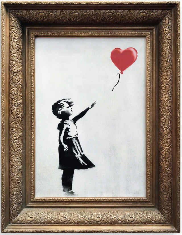영국의 거리예술가 뱅크시의 작품 ‘빨간 풍선과 소녀’. 이 작품은 지난 5일(현지시간) 런던 소더비 경매에서 약 15억원에 낙찰된 동시에 원격 조종으로 파쇄됐다. /사진제공=Sotheby