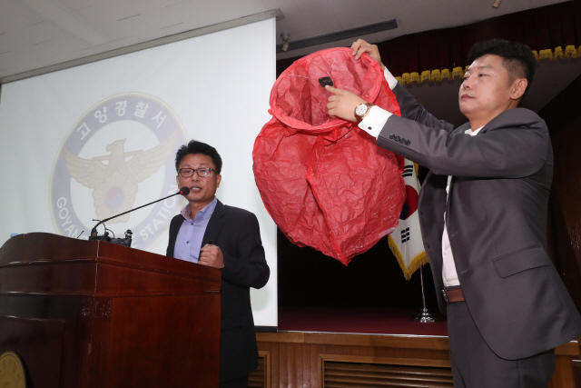 9일 경기 고양경찰서에서 한 경찰이 고양 저유소 폭발의 원인으로 지목된 풍등과 동일한 제품을 들어 보이고 있다. /고양=연합뉴스