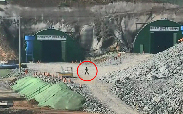 사진은 경찰이 공개한 CCTV에서 A씨가 저유소 쪽으로 날아가는 풍등을 향해 달려가는 모습./사진=고양경찰서 제공