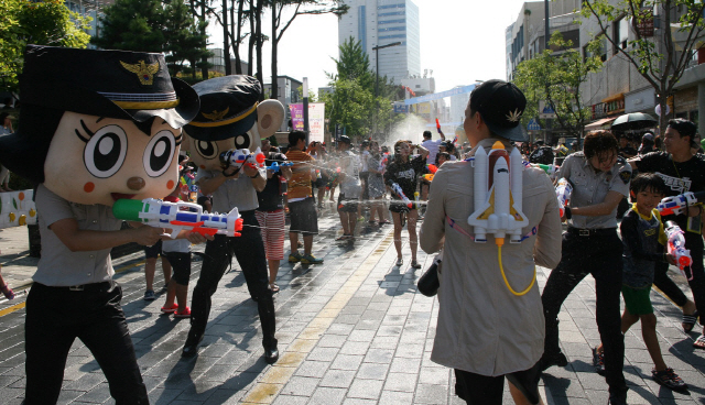 지난 2015년 8월 대전 중구에서 열린 ‘제1회 대전 물총축제’ 참가자들이 성범죄 예방 캠페인을 위해 바바리맨 복장을 한 경찰 관계자를 향해 물총을 쏘고 있다./대전=연합뉴스