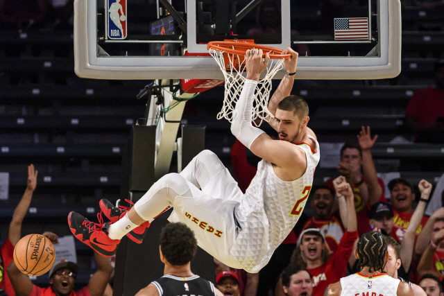 Atlanta Hawks center Alex Len hangs from the rim after a dunk during the first half of the team‘s preseason NBA basketball game against the San Antonio Spurs in Atlanta, Wednesday, Oct. 10, 2018. (AP Photo/Danny Karnik)      <저작권자(c) 연합뉴스, 무단 전재-재배포 금지>