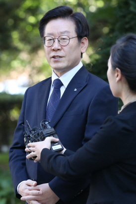 12일 경찰의 압수수색을 받은 이재명 경기도지사가 경기도 성남시 자택에서 출근하며 취재진의 질문에 답하고 있다. /성남=연합뉴스