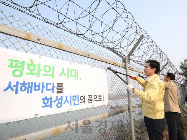 서철모(왼쪽) 화성시장이 15일 서해안 군사 철조망 제거 행사에 참여해 철책을 자르고 있다. /사진제공=화성시청