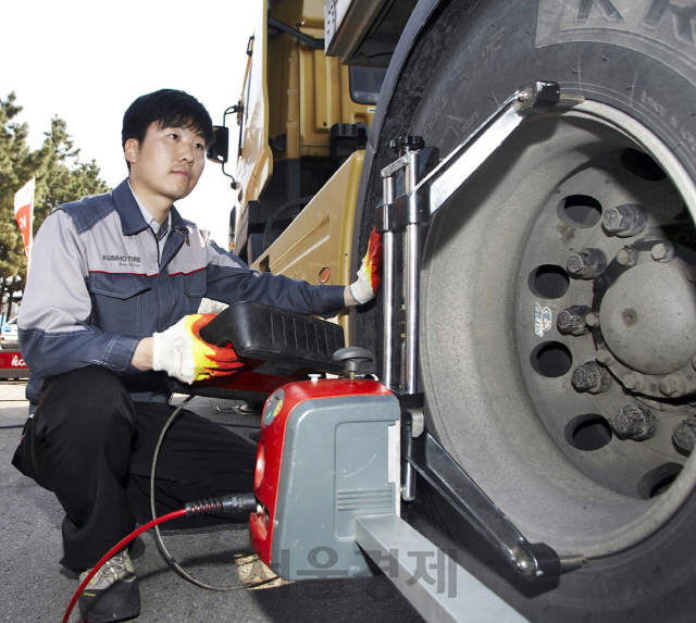 금호타이어의 직원이 고속도로 휴게소에서 트럭의 타이어 상태를 점검하고 있다./사진제공=금호타이어
