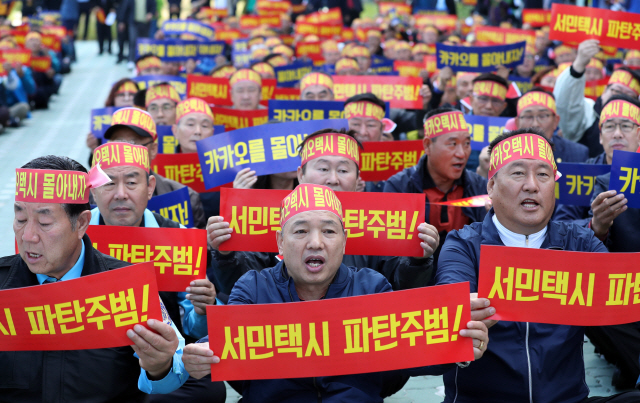 택시 노사 4개 단체로 이뤄진 ‘불법 카풀 관련 비상대책위원회’ 회원들이 4일 오전 경기도 성남시 판교 카카오모빌리티 사옥 앞에서 택시 생존권 사수 결의대회를 열고 카카오의 카풀 서비스 출시를 반대하는 내용의 구호를 외치고 있다./연합뉴스