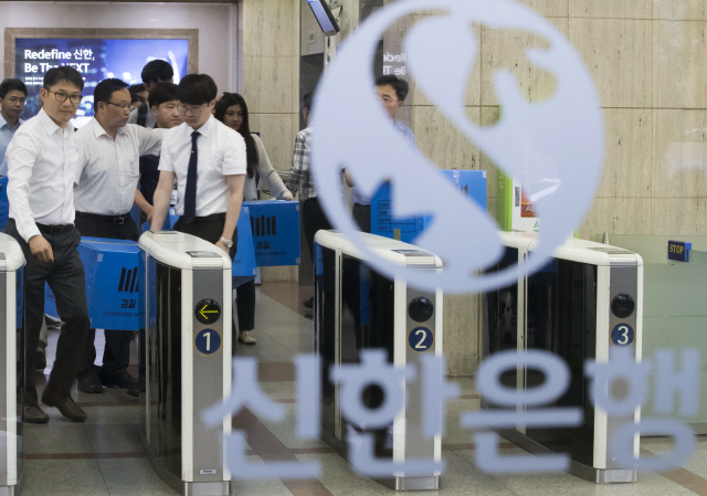 지난 6월 서울 중구 신한은행 본사 압수수색을 마친 검찰이 압수수색 물품을 들고 건물을 나서고 있다./연합뉴스