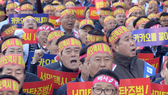 택시업계 노사 4개 단체로 이뤄진 ‘불법 카풀 관련 비상대책위원회’가 지난 11일 경기도 판교 카카오모빌리티 본사 앞에서 집회를 열어 출퇴근 승차공유 서비스인 ‘카풀’ 사업 중단을 요구하고 있다.  /연합뉴스