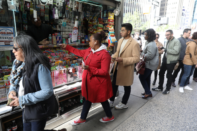 19일(현지시간) 미국 뉴욕 맨해튼에 있는 복권 판매처 앞에 사람들이 메가밀리언 복권을 사기 위해 줄을 서고 있다. /맨해튼=로이터연합뉴스