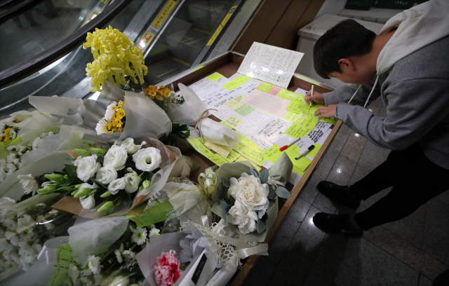 21일 오후 서울 강서구의 한 PC방 앞에 흉기 살인사건으로 목숨을 잃은 아르바이트생을 추모하는 공간에서 학생들이 추모 메시지를 작성하고 있다. /연합뉴스