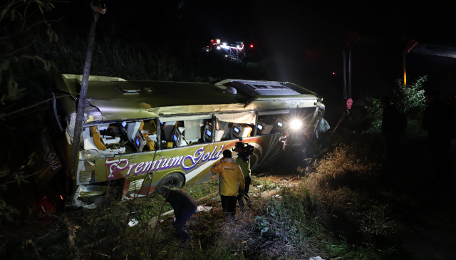 23일 오후 충남 천안논산고속도로 논산시 영창교 인근에서 21인승 고속버스가 가드레일을 뚫고 5m 아래로 떨어지는 사고가 발생한 가운데 구조대원들이 현장 주변을 살피고 있다. 이 사고로 50대로 추정되는 여성이 숨지고 13명이 다쳐 인근 병원으로 옮겨졌다./논산=연합뉴스